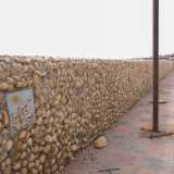 ...delimitata da un muretto fatto di ciottoli in cui sono incastonati dei disegni su ceramica
